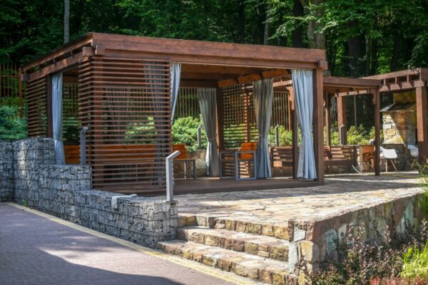 A wooden terrace with blinds and curtains.